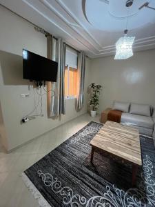 a living room with a couch and a table at Un appartement cosy in Oujda