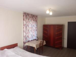 a bedroom with a bed and a table and a dresser at Guest house with two rooms in Zugdidi