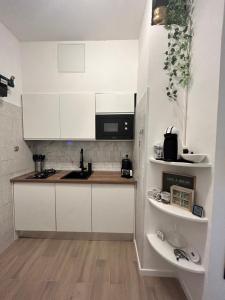 a kitchen with white cabinets and a counter top at Mini Loft - convenient for Venice in Venice