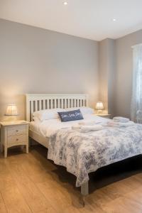 a bedroom with a large bed and two night stands at Carlton Lodge, Two bedroom apartment with parking space in Broadstairs
