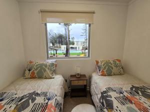 a bedroom with two beds and a window at Departamento en el Tabo Parquemar 4 in El Tabo +23 photos