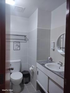 a white bathroom with a toilet and a sink at ManTa Vibe at Mesavirre Garden Residences in Bacolod