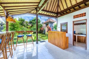 a kitchen with a bar with stools and a view at Lumbung Sari villa ubud in Ubud