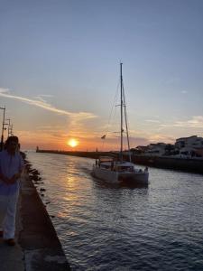una mujer de pie junto a un río con un barco en L'Azalée, city center apartment, en Capbreton