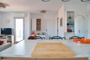 una cocina con una mesa con una tabla de cortar de madera. en L'Azalée, city center apartment, en Capbreton