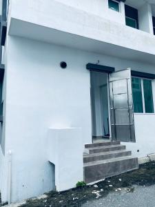 un edificio blanco con escaleras y una puerta en Homestay Bintang Maya, en Sungai Petani