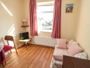 a living room with a couch and a window at Sycamore in Filey