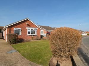 a brick house with a bush in front of it at Sycamore in Filey