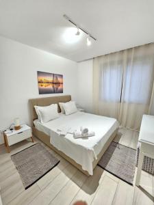 a white bedroom with a bed and a window at "Luxe Residence" Marsa avec Parking in La Marsa