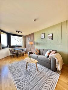 a living room with a couch and a table at Alpine Aura Hohegeiß in Braunlage +24 photos