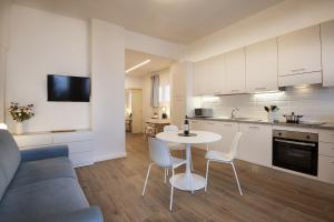una cucina e un soggiorno con tavolo e sedie di LARÙ - 8 Minutes from the Duomo a Milano