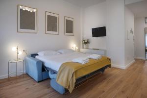una camera da letto con un letto blu e una televisione di LARÙ - 8 Minutes from the Duomo a Milano