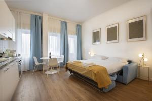 una camera da letto con un letto, un tavolo e una cucina di LARÙ - 8 Minutes from the Duomo a Milano