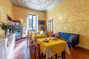 a restaurant with tables and chairs and yellow walls at Hotel Costantini in Florence