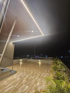 a large room with a wooden floor and lights at Pine Tree Garden - No Alcohol Zone in Yelagiri +5 photos