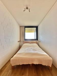 a small bedroom with a bed and a window at Alpine Aura Hohegeiß in Braunlage