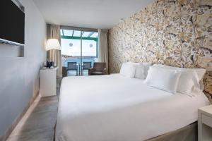 a bedroom with a large white bed in a room at Barceló Teguise Beach - Adults Only in Costa Teguise