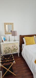 a bedroom with a bed and a table with a mirror at Casa do Bairro - O seu refúgio in Ponta Delgada