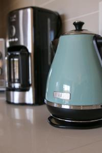 a tea kettle sitting on a counter next to a coffee maker at The Jade Somerset West in Cape Town +17 photos