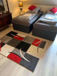 a living room with two beds and a rug at Studio 29 in Oberhausen