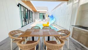 a table and chairs on the balcony of a house at Wana Villa ChaAM in Cha Am