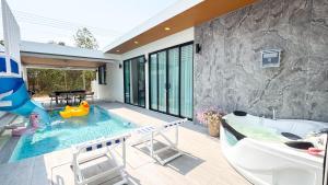an indoor swimming pool with a tub and a swimming pool at Wana Villa ChaAM in Cha Am