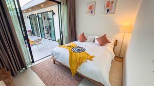 a bedroom with a bed with a yellow blanket on it at Wana Villa ChaAM in Cha Am +70 photos