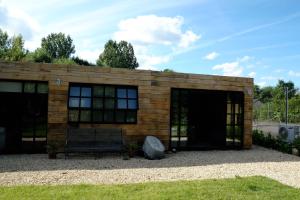 un pequeño edificio con un banco delante en Brandiers Box, en Malmesbury