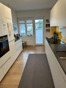 巴塞尔ESC-Basel-Flat - Whole rent to save our MUSICAL THEATER BASEL的厨房配有白色橱柜和大窗户