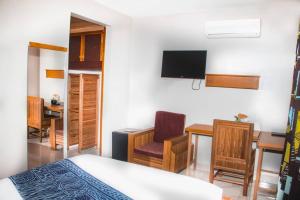 a bedroom with a bed and a desk and a tv at CONGRESS HOTEL Yaoundé in Yaoundé
