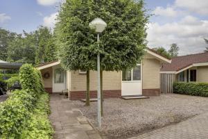 a house with a street light in front of it at Luxe boshuisje op kleinschalig park op de Veluwe in Putten