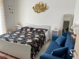 a bedroom with a bed and a blue couch at La Ginestra in Giardini Naxos