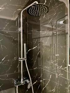 a bathroom with a shower with a black marble wall at Lecce Holiday Rentals in Lecce
