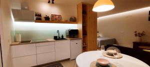 a kitchen with white cabinets and two tables in a room at Estudio centro de La Laguna in Las Lagunas