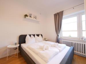 a bedroom with a bed with white sheets and a window at Erdgeschosswohnung, zentral, ruhige Lage in Paderborn