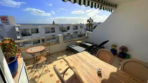 a balcony with a table and chairs on a building at App 308 - Wundervoller Meerblick, sehr zentrale Lage, angenehm ruhig in Tías