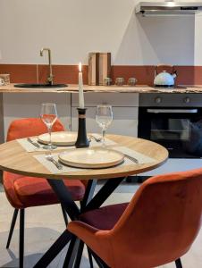 a table with two wine glasses and a candle on it at Le Rituel in Fréchencourt +17 photos