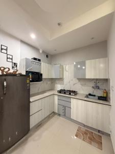 a kitchen with white cabinets and a stainless steel refrigerator at Shelbys Abode in Dehradun
