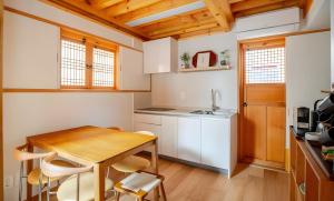 una pequeña cocina con mesa de madera y sillas en Numaru Stay - Luxury Private Hanoks in Seochon, Seoul, en Seúl 44 fotos más