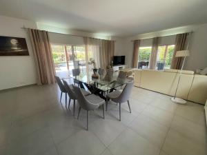 Un comedor con una mesa de cristal y sillas. en Agence Adjana Resort - Résidence SAFARI VILLAGE, en Sali Tapé