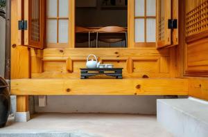 un edificio de madera con un banco en una habitación en Numaru Stay - Luxury Private Hanoks in Seochon, Seoul, en Seúl