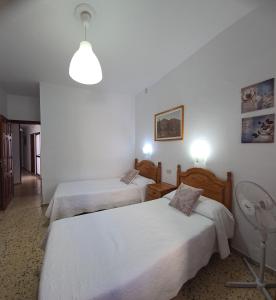 a hotel room with two beds and a lamp at Pensión Los Volcanes in Fuencaliente de la Palma