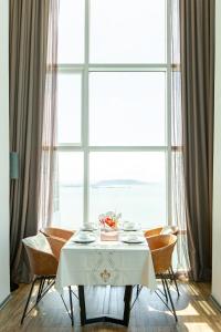 a table with chairs and a white table and a window at Penang Oceanview Loft in George Town