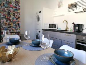a kitchen with a table with bowls and wine glasses at M-OASE Blue Design I Citynah I Küche I Netflix in Braunschweig