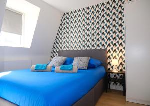 a bedroom with a blue bed with blue pillows at Your Home Loos 2 - Proche Lille in Loos