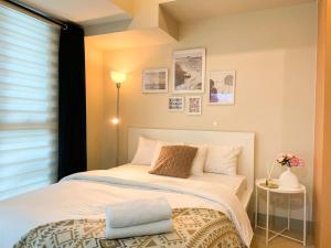 une chambre avec un lit et une fenêtre dans l'établissement Elegant BGC Condo Across Mitsukoshi Mall #upt27p, à Manille 26 autres photos