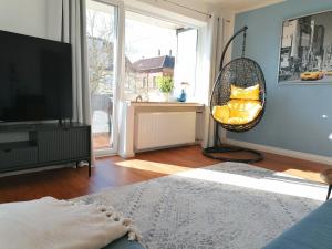 a living room with a swing chair and a television at M-OASE Blue Design I Citynah I Küche I Netflix in Braunschweig