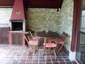 eine Terrasse mit einem Tisch, Stühlen und einem Kamin in der Unterkunft La Casa de las Ostras in Mogro + 8 Fotos