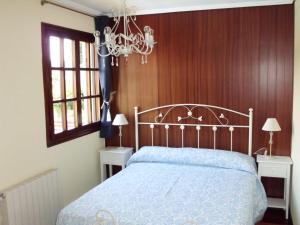 ein Schlafzimmer mit einem Bett und einem Kronleuchter in der Unterkunft La Casa de las Ostras in Mogro