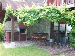 eine Pergola mit einem Tisch und Stühlen auf einer Terrasse in der Unterkunft La Casa de las Ostras in Mogro